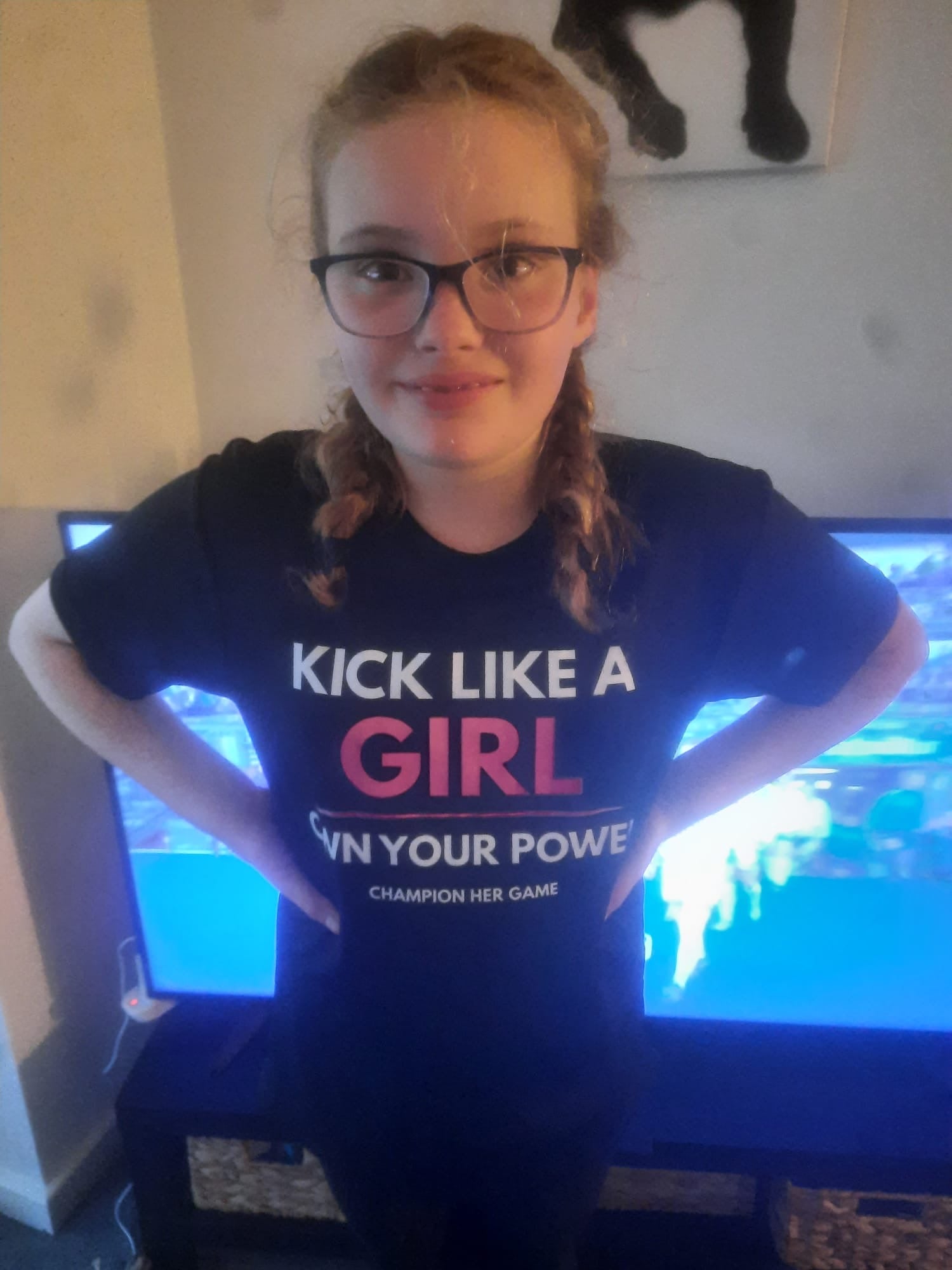 Girl wearing a black t-shirt with Kick Like A Girl - own your power