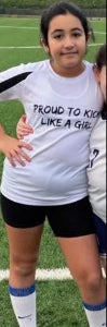 Person wearing a soccer jersey with text on a grass field